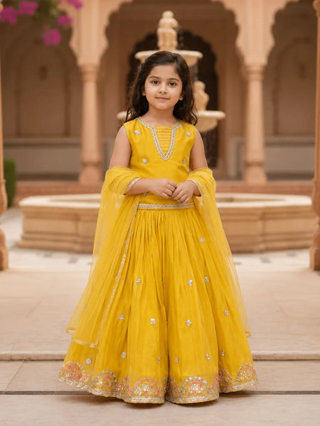 Young girl in a yellow traditional outfit standing in front of architectural background
