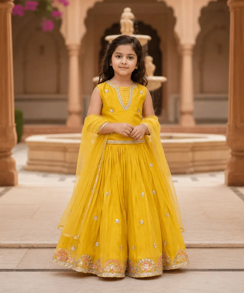 Young girl in a yellow traditional outfit standing in front of architectural background