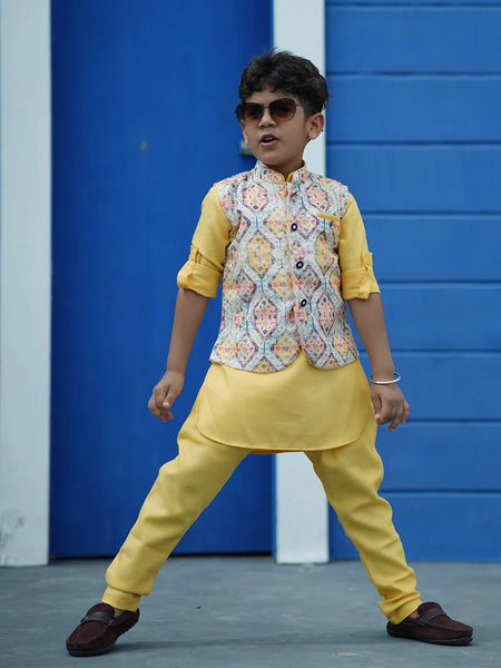This classic yellow colored kurta set is curated from high quality fabric. It comes along with matching pajama and sleeveless printed Nehru jacket that features stylized buttons for boys. 